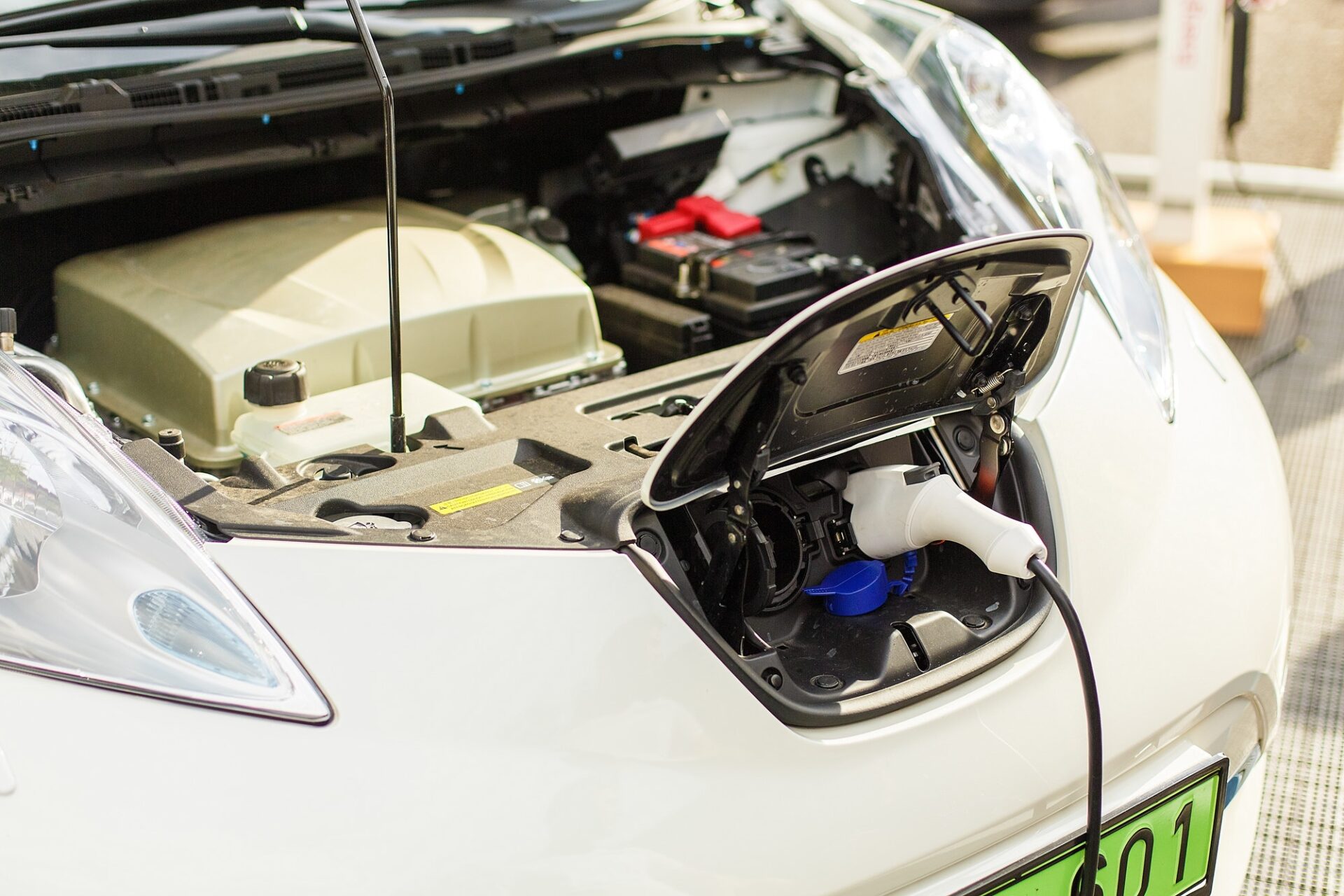 Voiture EV ou voiture électrique à la station de recharge avec l'alimentation du câble d'alimentation branchée sur un fond flou avec une lumière douce.