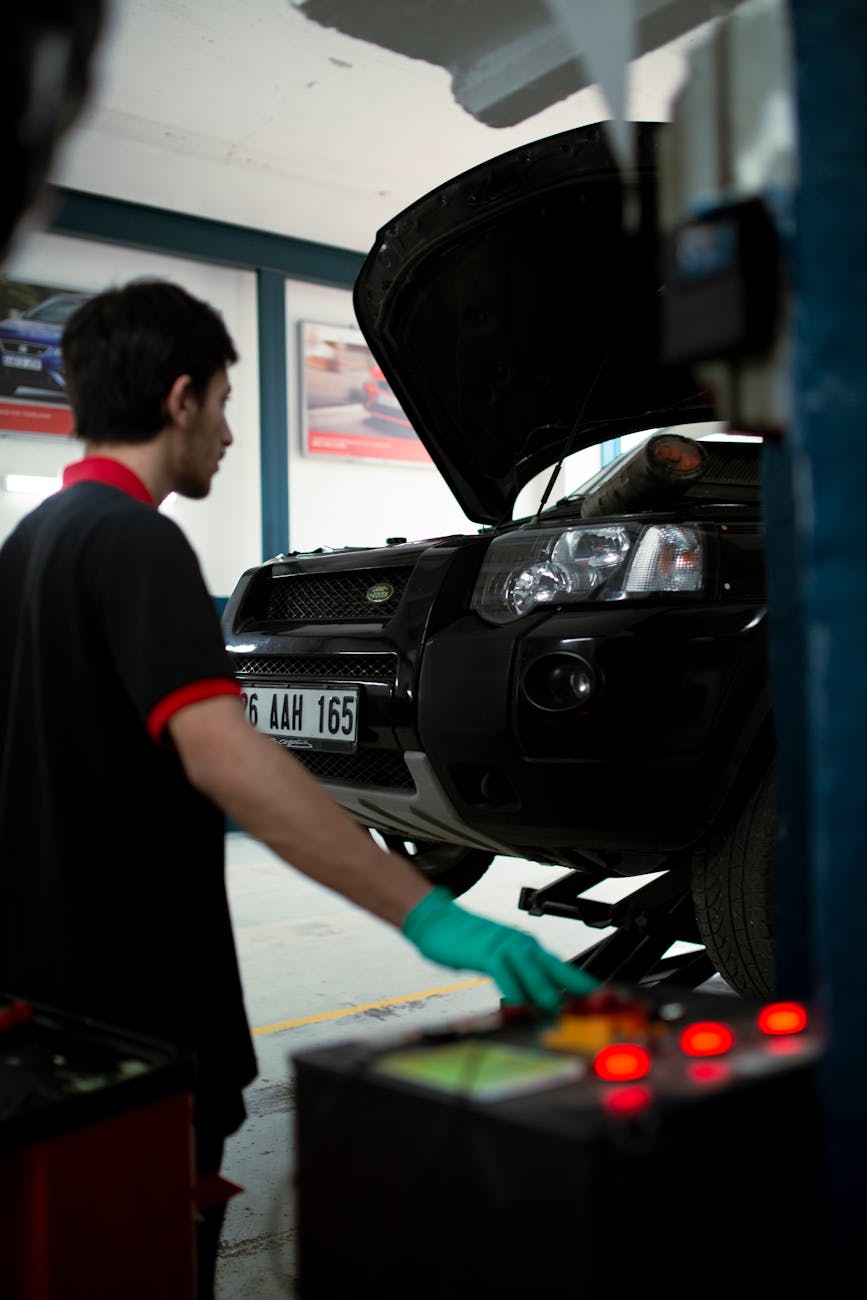 Mécanique utilisant l'équipement pour élever le SUV pour inspection dans un garage automobile.