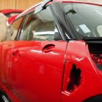 Carrosserie rouge du service de voiture à l'atelier de détail des véhicules.