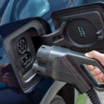 La main humaine tient la charge de voiture électrique