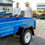 Agronome avec Salesman Choisant une nouvelle remorque de camion de ferme, debout sur le terrain ouvert de la boutique agricole