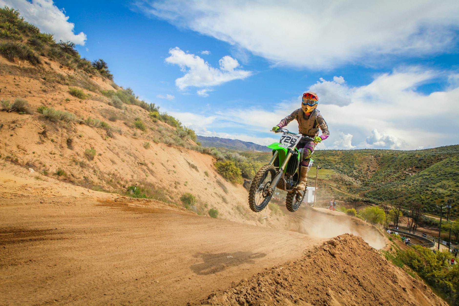 Action excitante de motocross avec un motard qui sautait sur une piste de terre pendant une course.