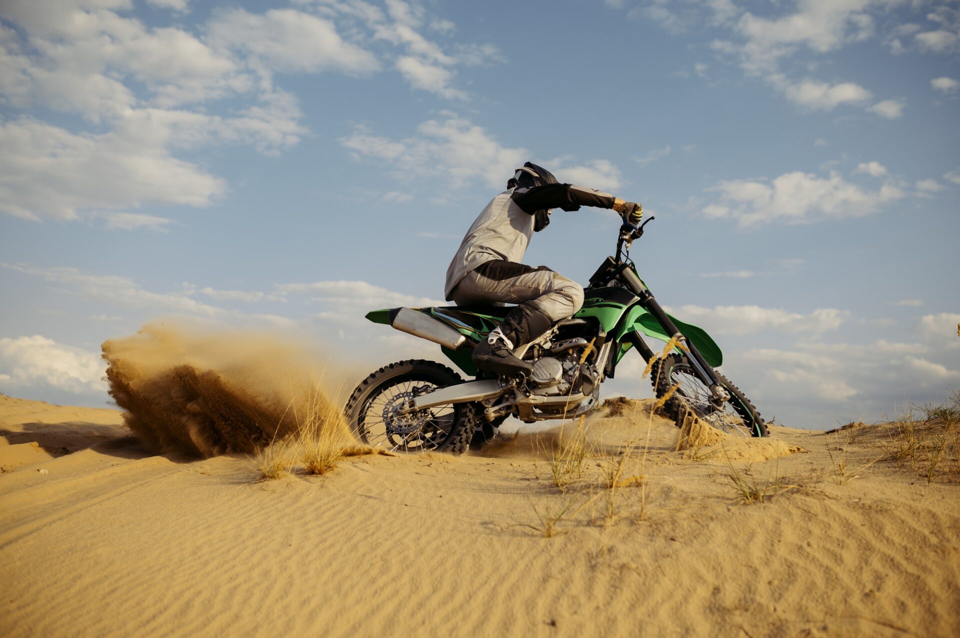 Le pilote de vitesse professionnelle conduisant dans la course de motocross tourne avec une pente.