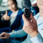 Client heureux montrant des clés électroniques de voiture qu'il vient d'acheter