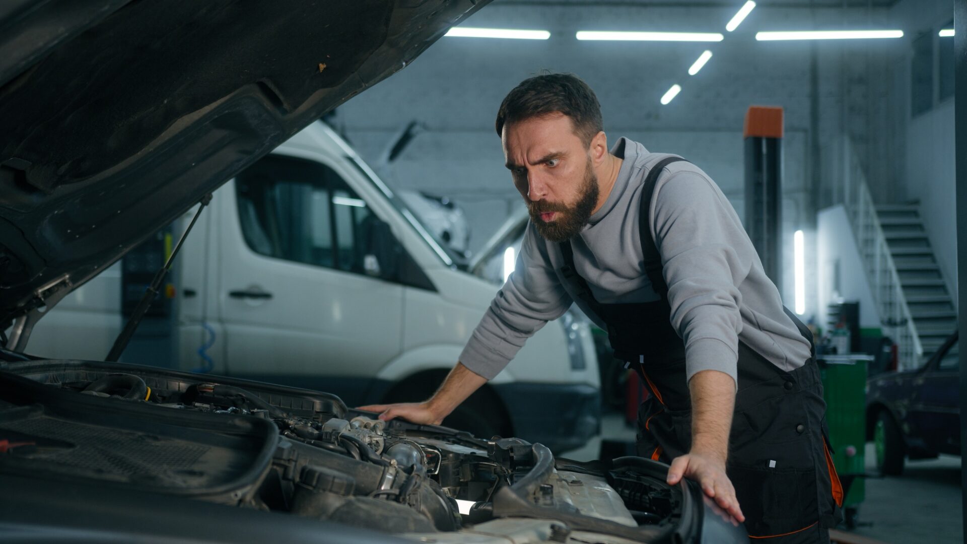 Confus choqué Caucasien Guy Man Mécanique automatique Réparant masculin Réparation de capuche ouverte Fixation de voiture cassée à la station de service Frotter la tête de la tête de la tête de l'automobile Crash Transport Transport Vehicle Repair in Garage.