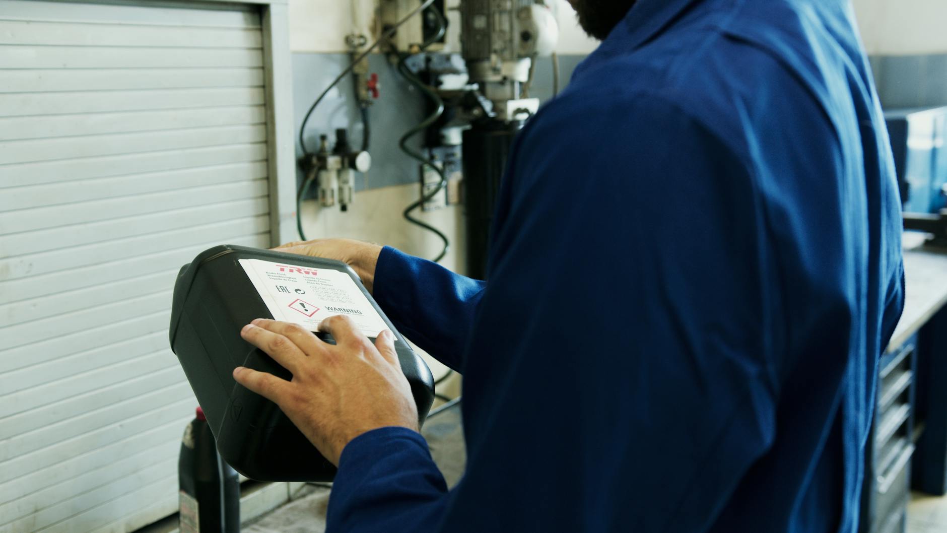 Mécanicien utilisant un outil de diagnostic pour inspecter le véhicule dans un atelier automobile.